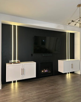 Modern living room with a television mounted on a black paneled wall.