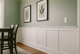 Elite Shaker Paneled Wainscoting Kit installed along a dining room wall, featuring primed shaker stiles, upper and lower rails, and a poplar cap trim in a clean white finish