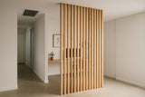 Wooden slat room divider in a modern interior setting. The vertical hardwood pieces create a stylish visual barrier between rooms.